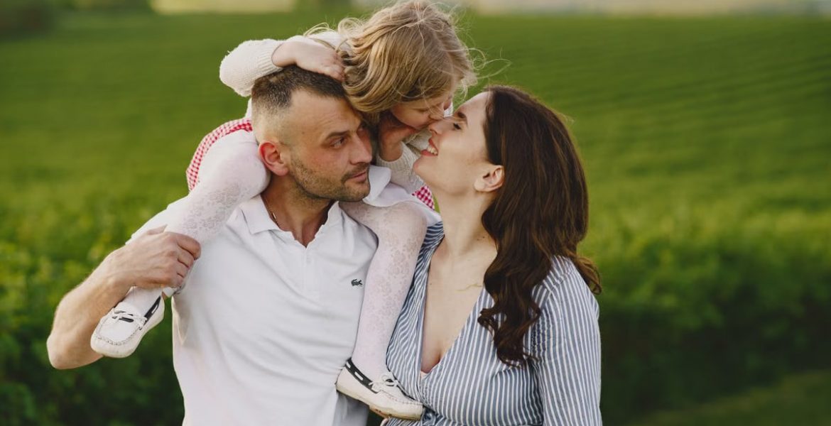 A delightful family moment captured in a lush scenic field, portraying love and happiness.